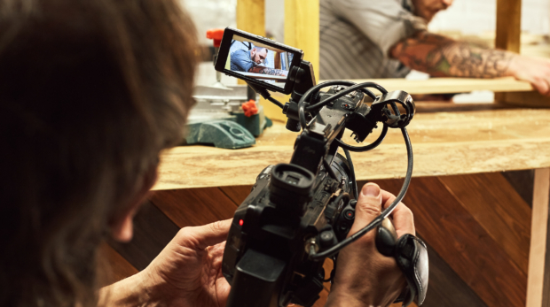 Video production backstage. Behind the scenes of creating video content, a professional team of cameramen with a director filming commercial ads. Video content creation, video creation industry